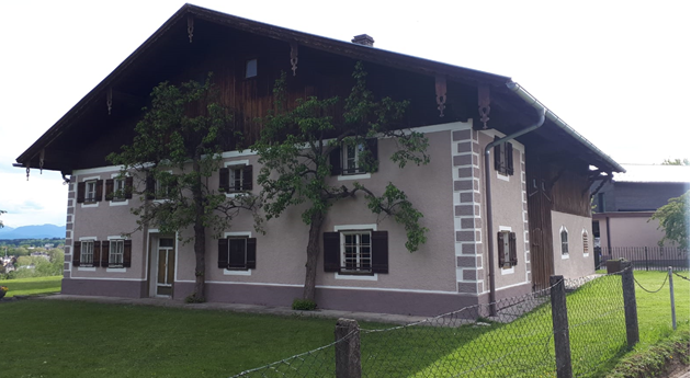 Ein großes Haus mit vielen Fenstern und einem Zaun davor