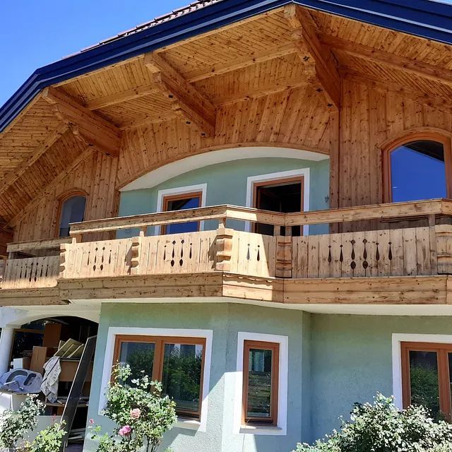 Ein Haus mit Balkon und blauem Dach