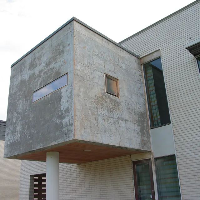 Ein Backsteingebäude mit einem quadratischen Fenster an der Seite