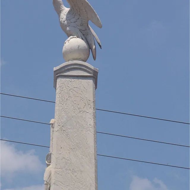 Eine Statue eines Vogels, der auf einer Stange sitzt
