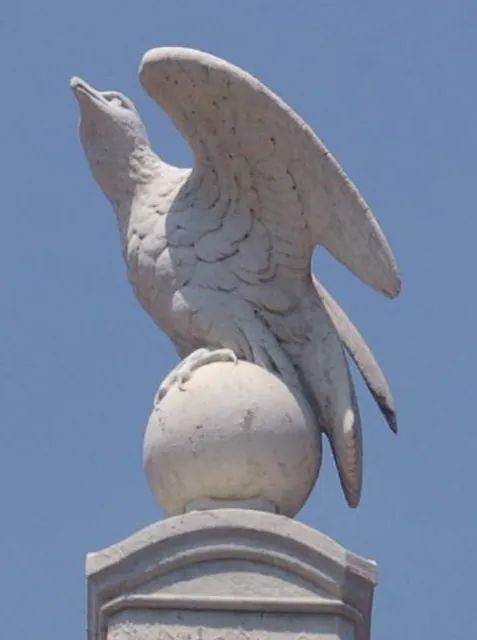 Eine Statue eines Vogels, der auf einem Ball sitzt