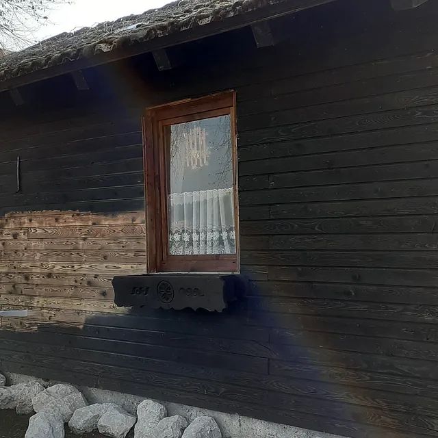 Ein Holzhaus mit einem Fenster an der Seite.