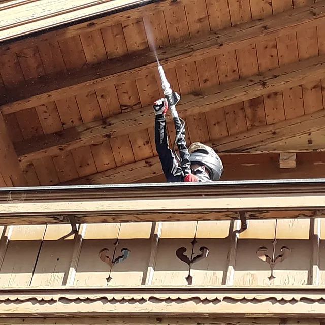 Ein Mann mit Helm steht auf einem Balkon und hält einen Schläger