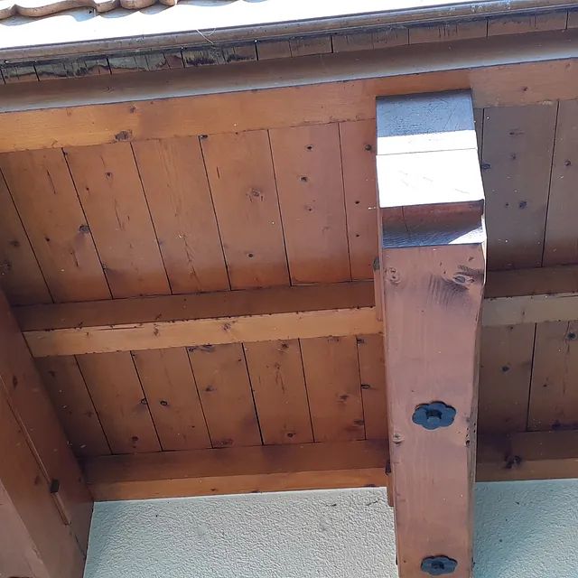 Eine Nahaufnahme einer Holzdecke mit einem Metallträger.