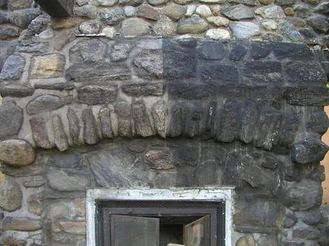 Eine Steinmauer mit einem Kamin in der Mitte.