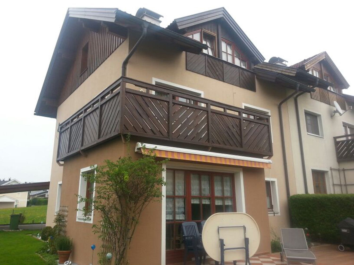 Ein Haus mit Balkon und einem Tisch davor