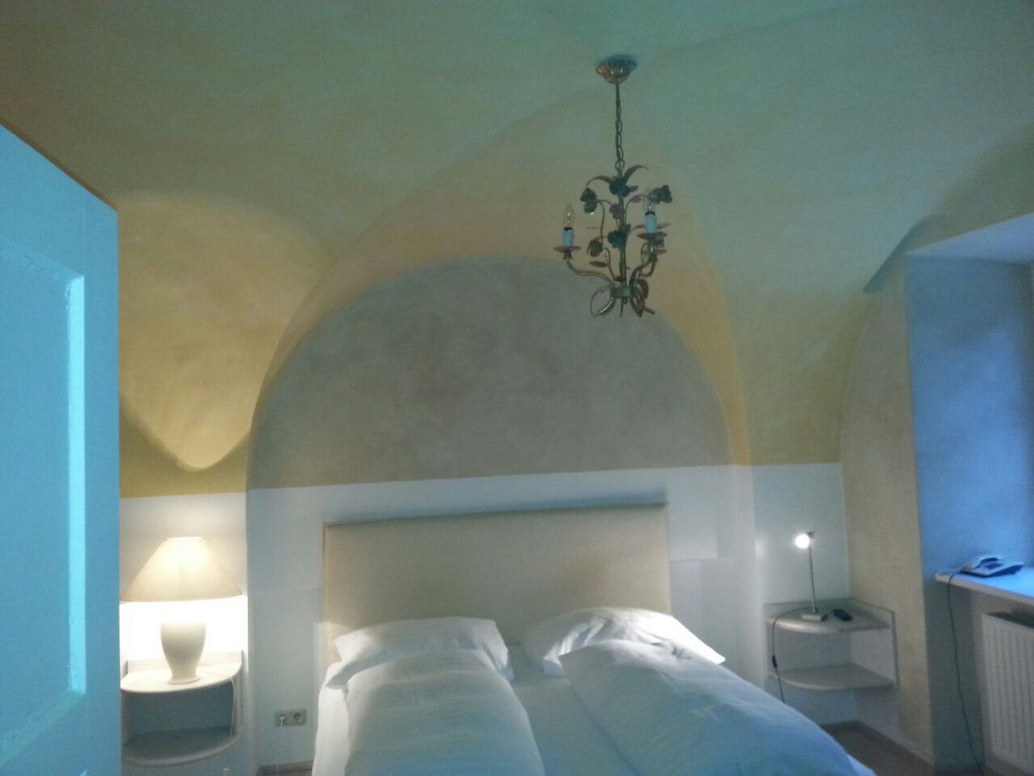 Ein Schlafzimmer mit einem Bett und einem Kronleuchter, der von der Decke hängt