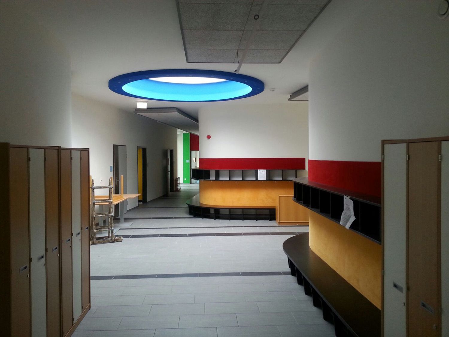 Ein Flur mit Schließfächern und einem blauen Licht an der Decke