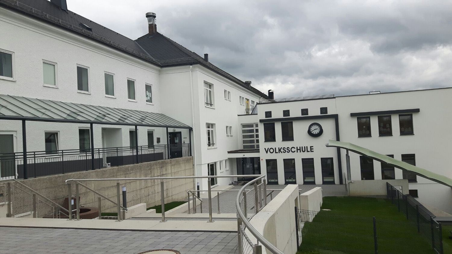 Ein großes weißes Gebäude mit einer Uhr an der Seite.