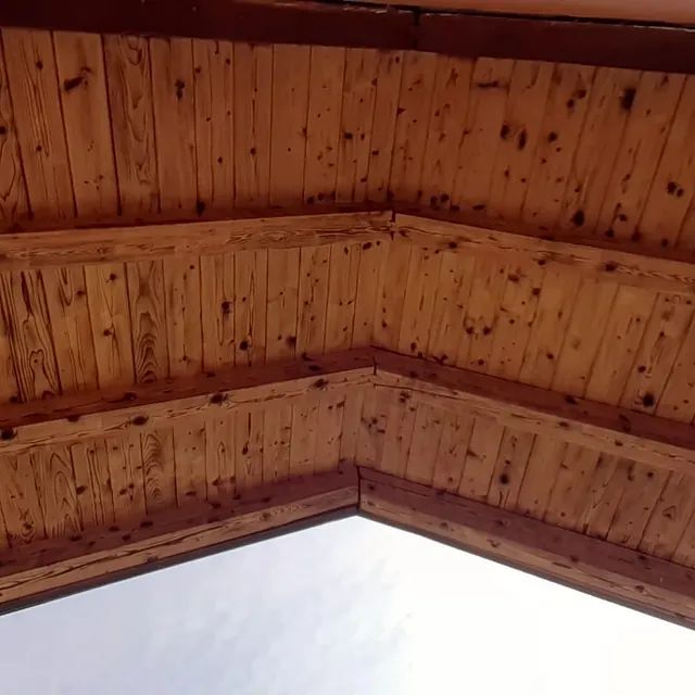 Eine Nahaufnahme einer Holzdecke vor weißem Hintergrund.