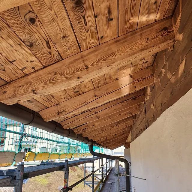 Ein Balkon mit Holzdach und Metallgeländer