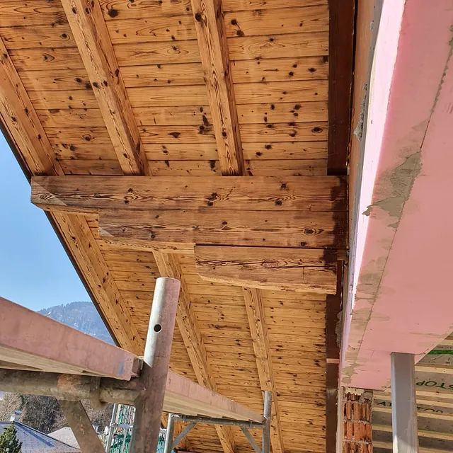 Auf einem Gebäude wird ein Holzdach errichtet.