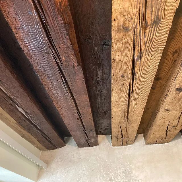 Eine Nahaufnahme von einem Holzbalken an einer Wand