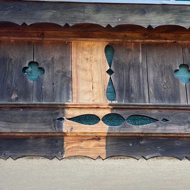 Eine Nahaufnahme einer Holzwand mit ein paar Löchern darin.