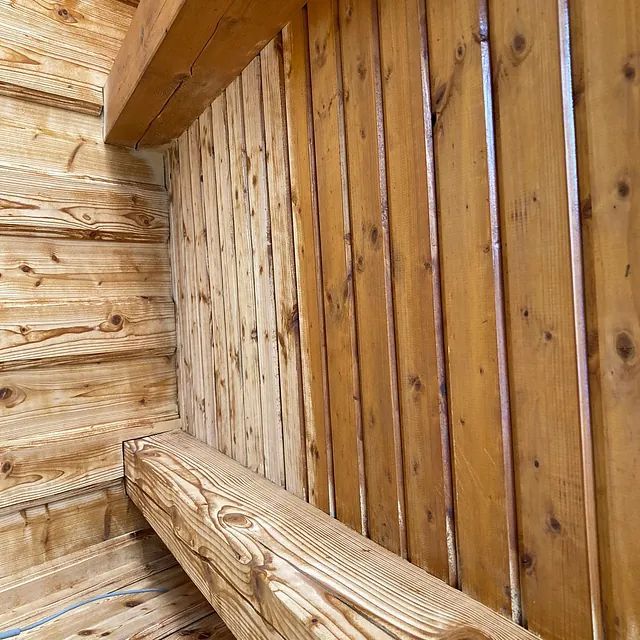 Eine Nahaufnahme einer Holzwand mit einem Regal in der Mitte.