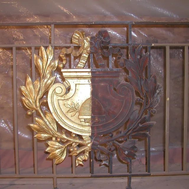 Ein goldenes und braunes Emblem auf einem Metallzaun