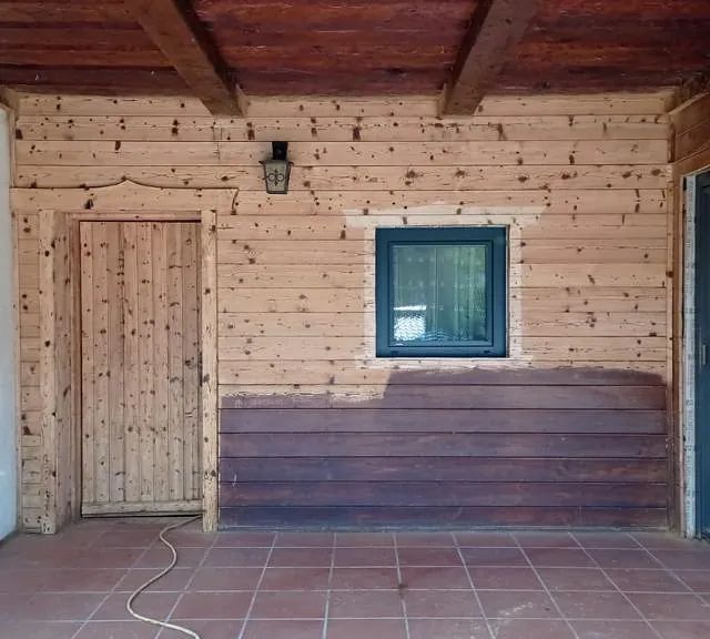 Ein leerer Raum mit einer Holztür und einem Fenster