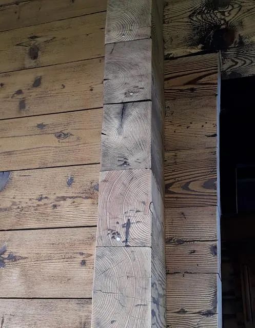 Eine Nahaufnahme eines Holzbalkens an einer Holzwand.