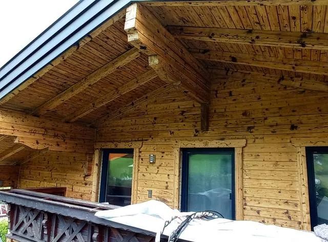 Ein Holzhaus mit Balkon und Dach