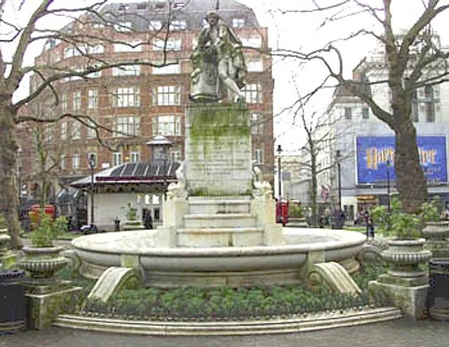 Ein Brunnen in einem Park vor einem Gebäude mit der Aufschrift „Harry Potter“