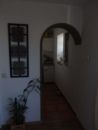 Ein Flur mit einem Torbogen, der zu einer Küche führt.