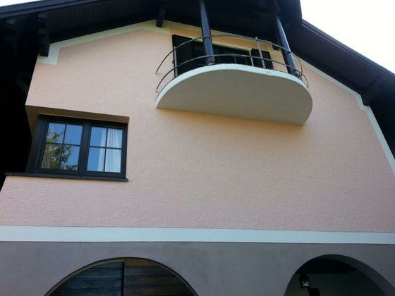 Ein Haus mit einem Balkon auf dem Dach