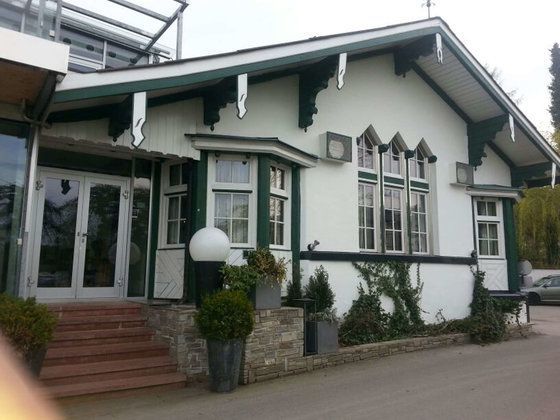 Ein weißes Haus mit grünem Dach und vielen Fenstern