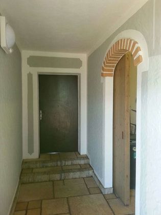 Ein Flur mit einer Tür und einer Treppe, die dorthin führt