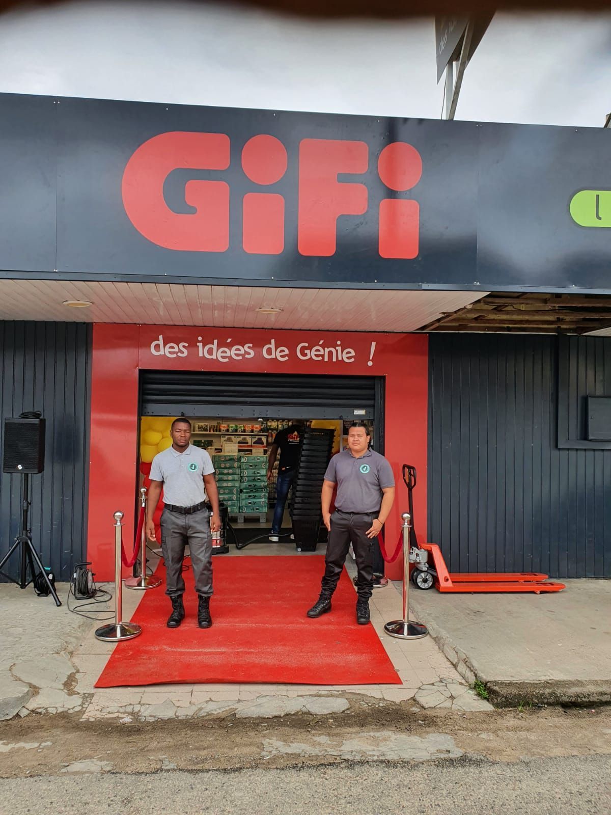 Photo de 2 membres du personnel devant un magasin