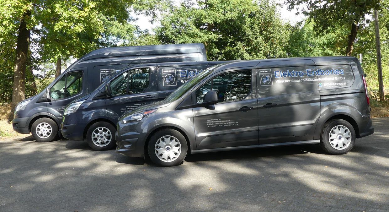 Zwei Lieferwagen stehen nebeneinander am Straßenrand.
