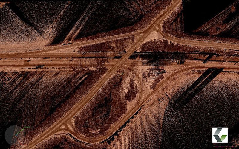 Datenvisualisierung eines Autobahnkreuzes in Form einer Punktwolke von oben, die Straßen, Überführungen und das umliegende Gelände in Brauntönen zeigt.