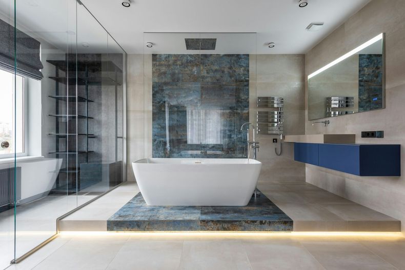 Modernes Badezimmer mit freistehender Badewanne, blauen Akzenten und Glasdusche.