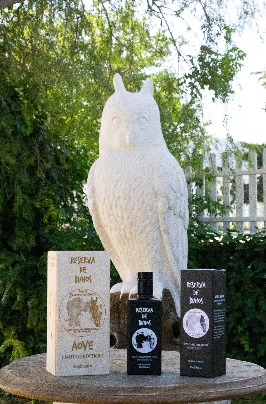 Una estatua de un búho está sentada junto a una botella de loción.
