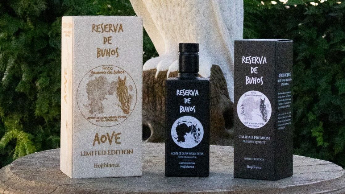Tres frascos de perfume están sobre una caja de madera sobre una mesa.
