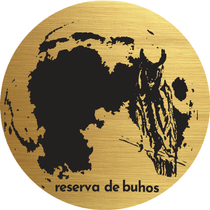 Moneda de oro con la ilustración de un búho negro y el texto "reserva de buhos".
