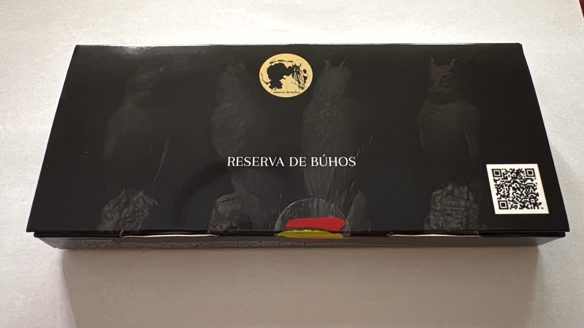 Estuche de regalo abierto con cinco frascos negros y un pequeño pincel, presentado en una caja negra.