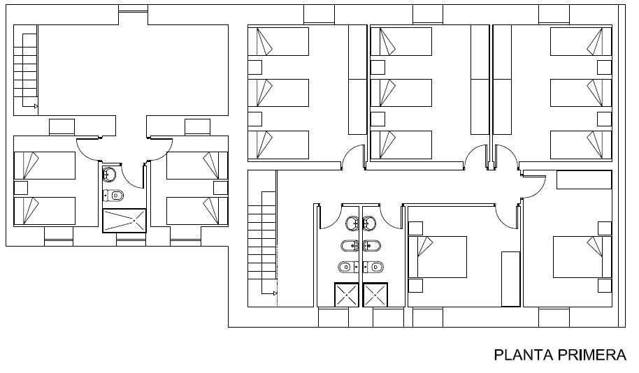 Plano de un edificio con varias habitaciones, baños y una escalera denominada 