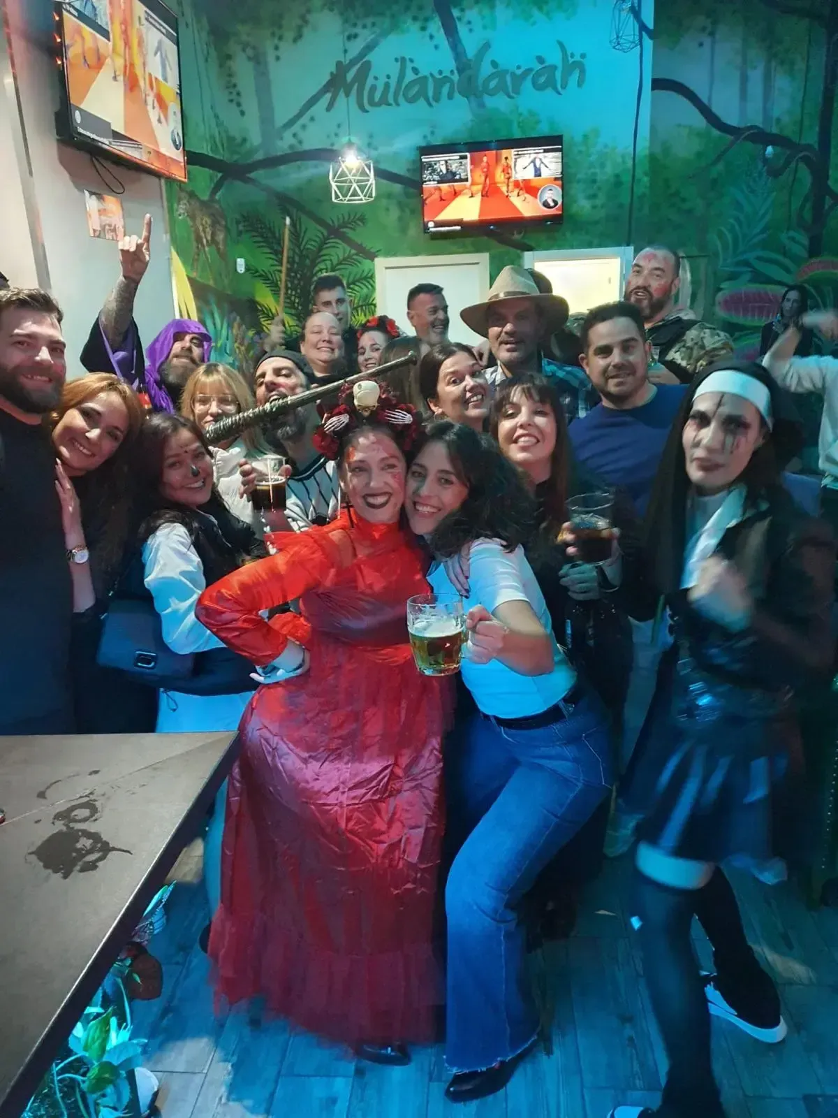 Un grupo de personas en un bar, algunas con bebidas en la mano