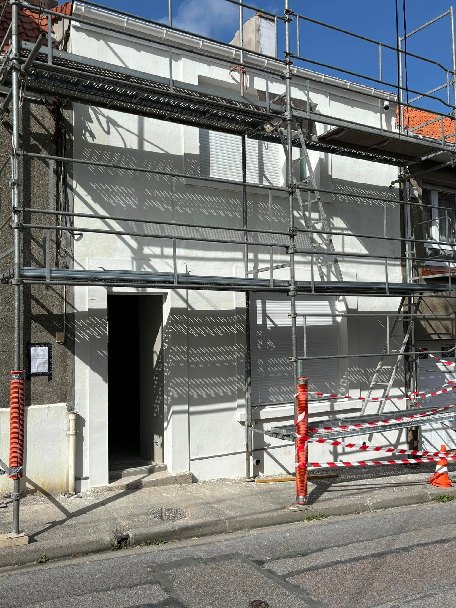 Façade d'un bâtiment en construction avec échafaudages.