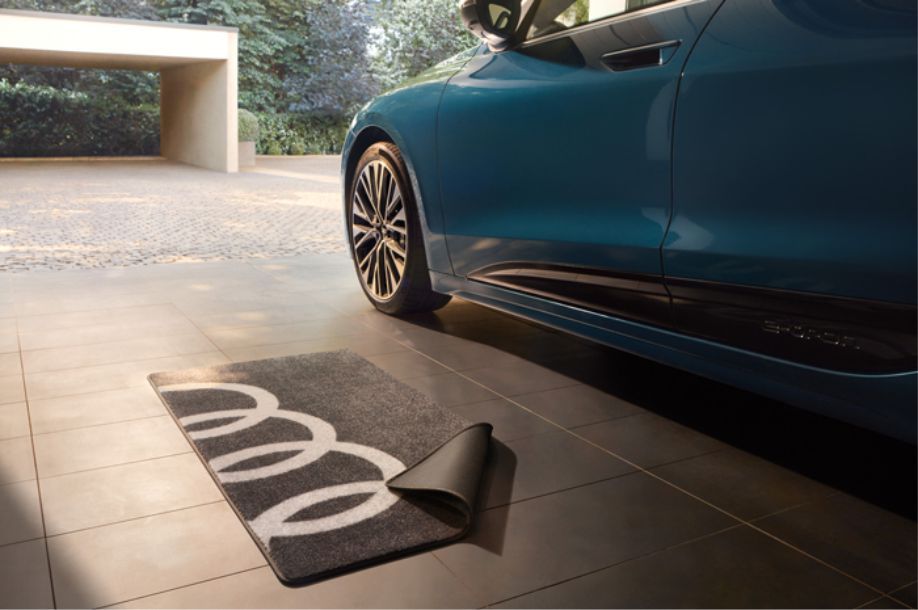 Blaues Auto in einer Garage mit einer Audi Fußmatte 