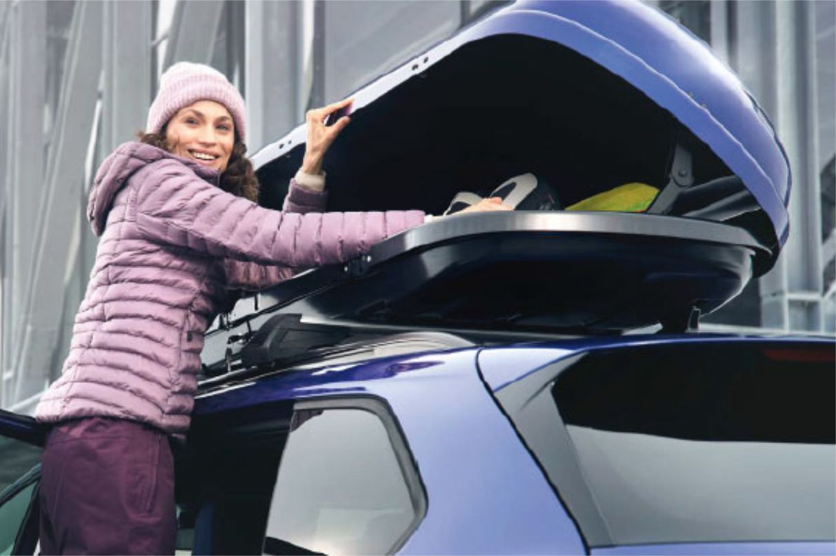 Frau am geöffneten Dachgepäckträger