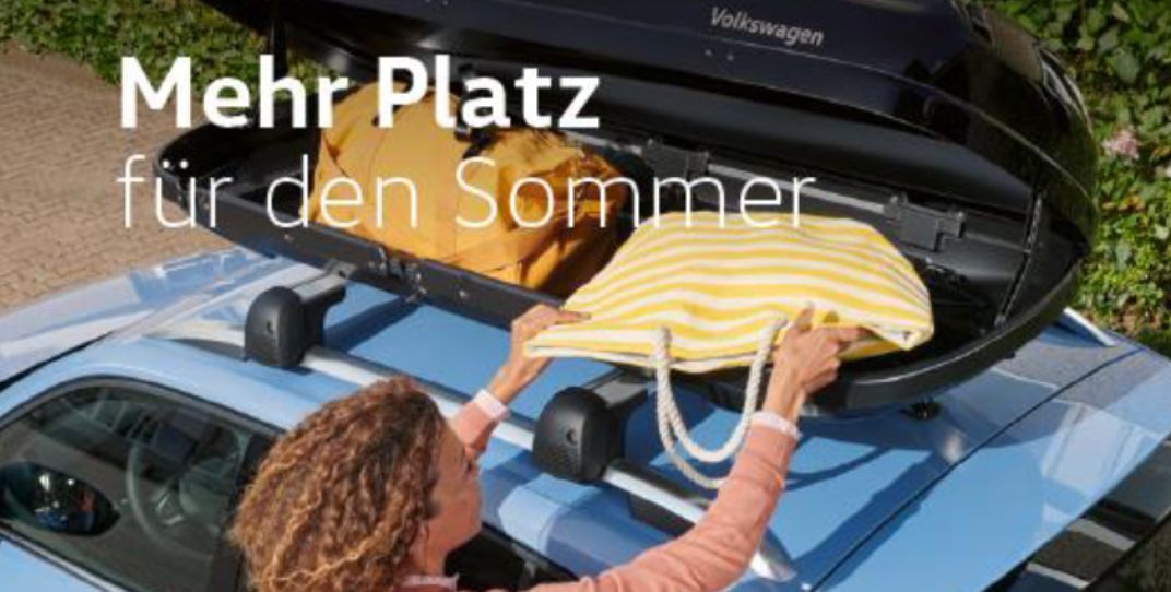 Frau packt Tasche in Dachbox