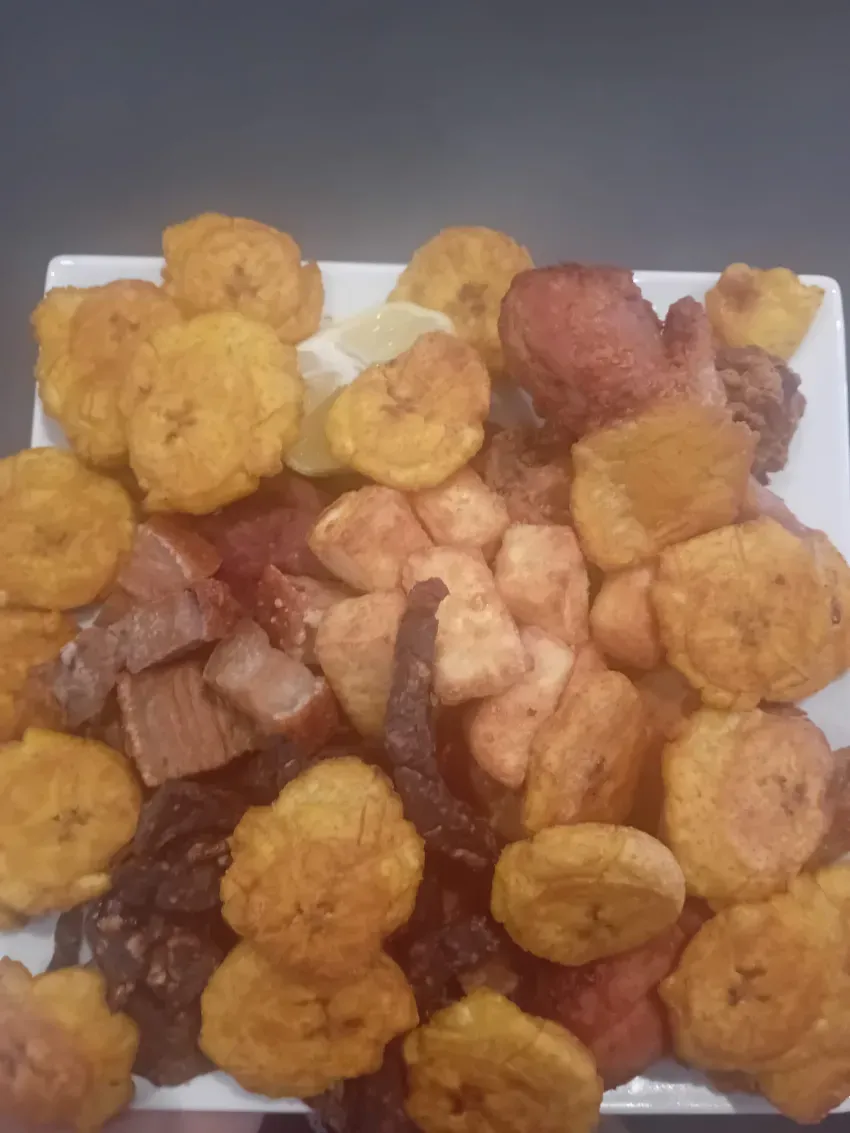 Surtido de aperitivos coloridos apilados en una bandeja blanca.