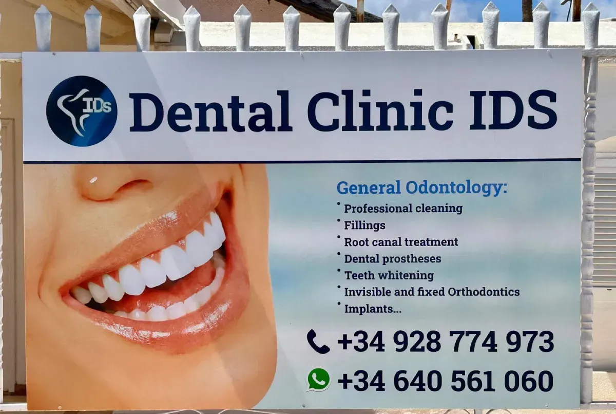El letrero de la Clínica Dental IDS enumera los servicios de odontología general y dos números de teléfono de contacto.