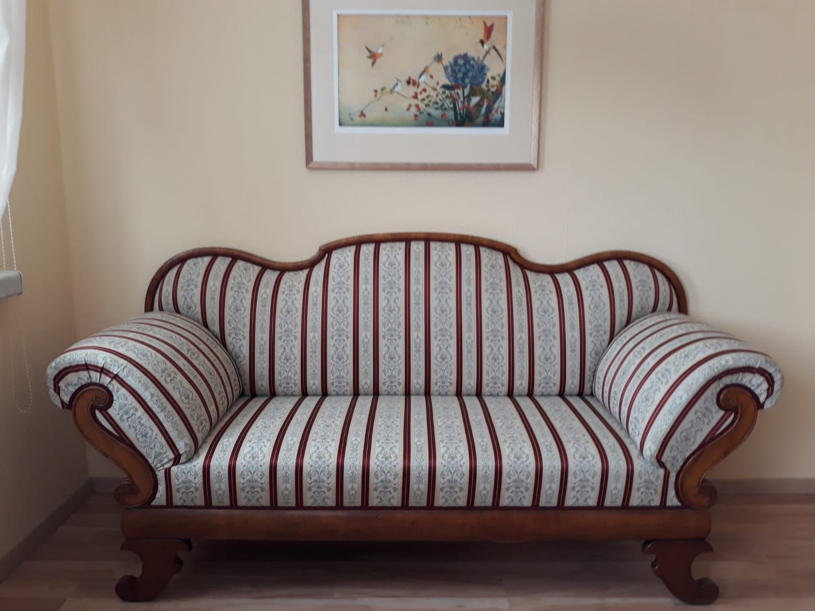 Gestreiftes Polstersofa im Wohnzimmer unter gerahmten Wandbildern