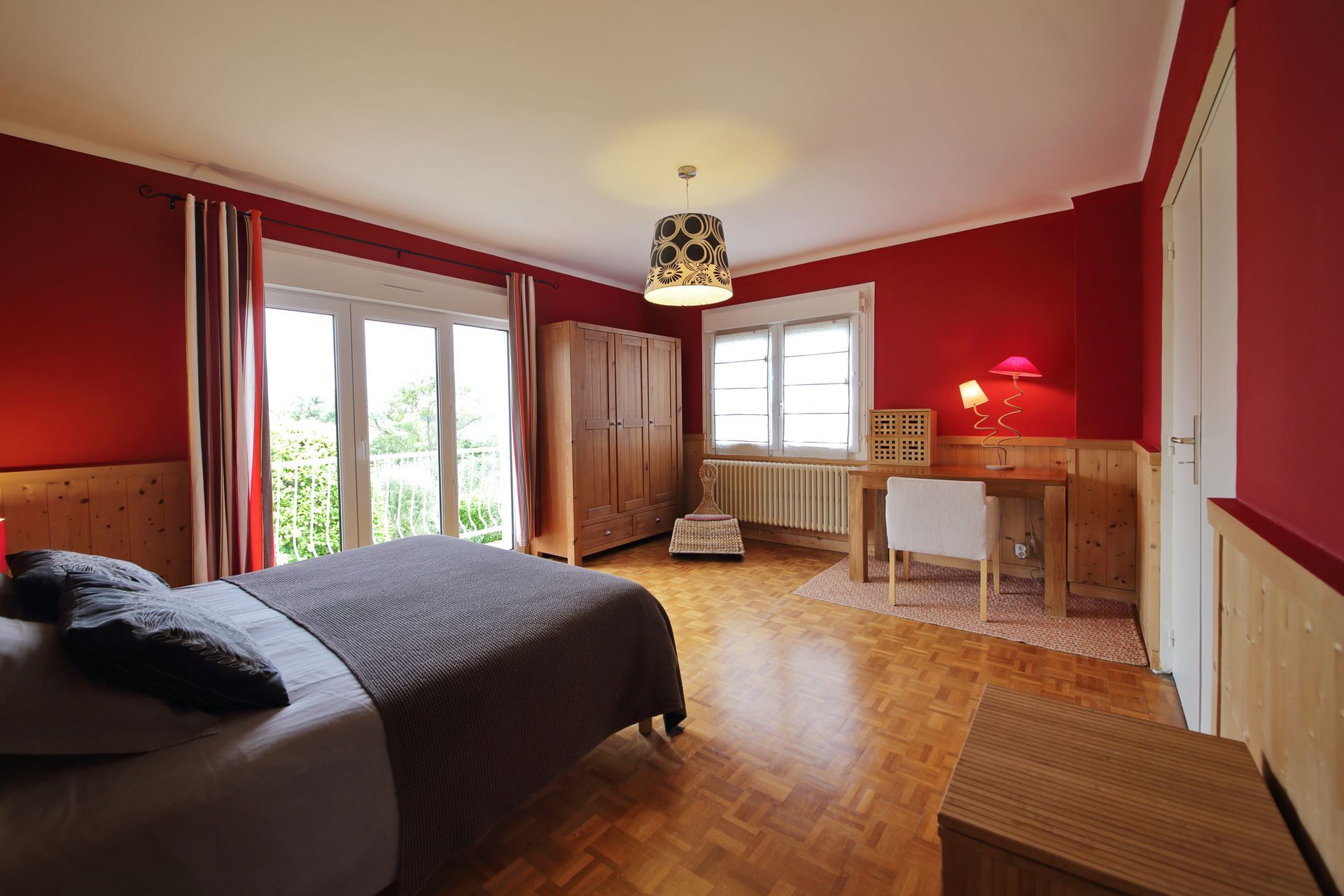 Chambre orange rouge avec un lit deux places et un bureau