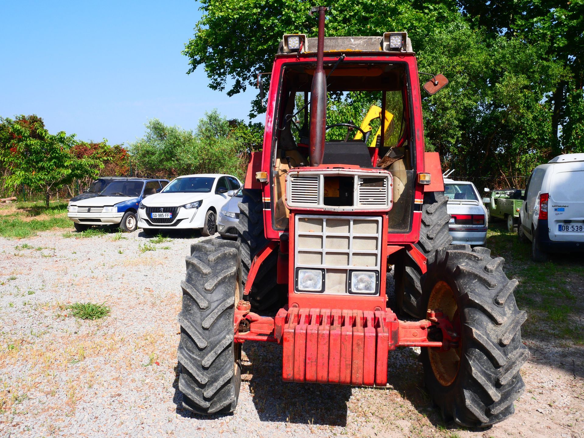 Tracteur garé devant des voitures
