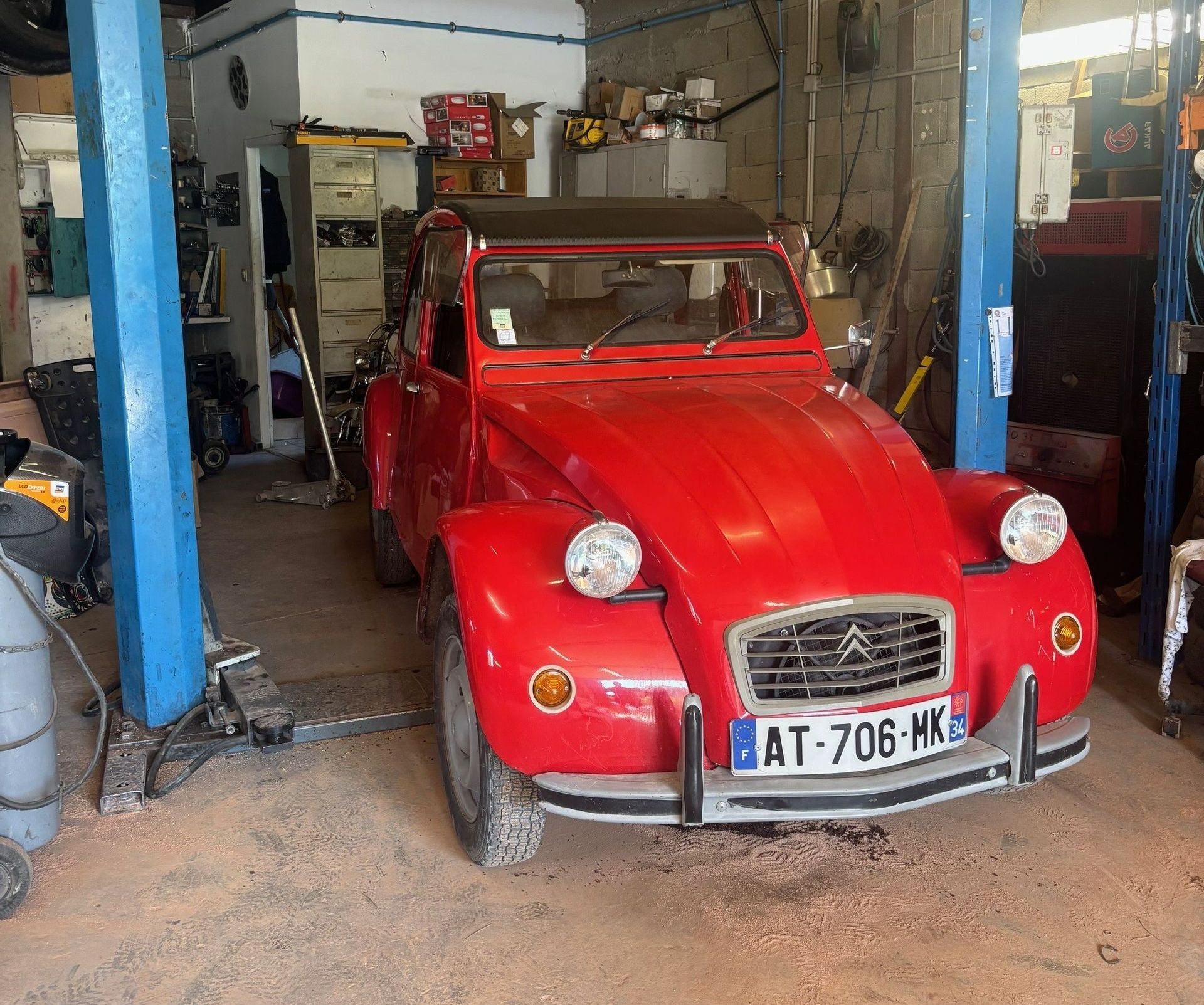 Une 2 chevaux rouge au garage