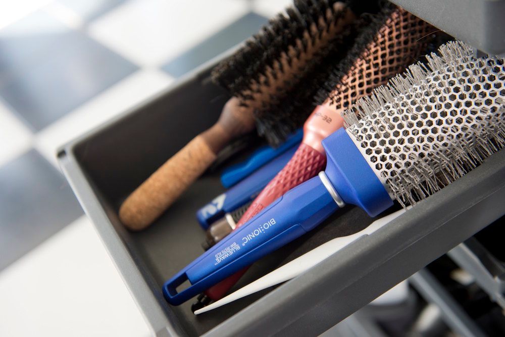 In einer Schublade liegt ein Haufen Haarbürsten.