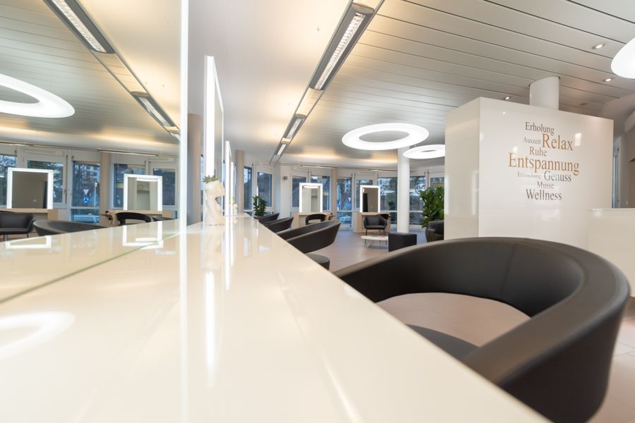 Ein Friseursalon mit vielen Stühlen und Spiegeln.